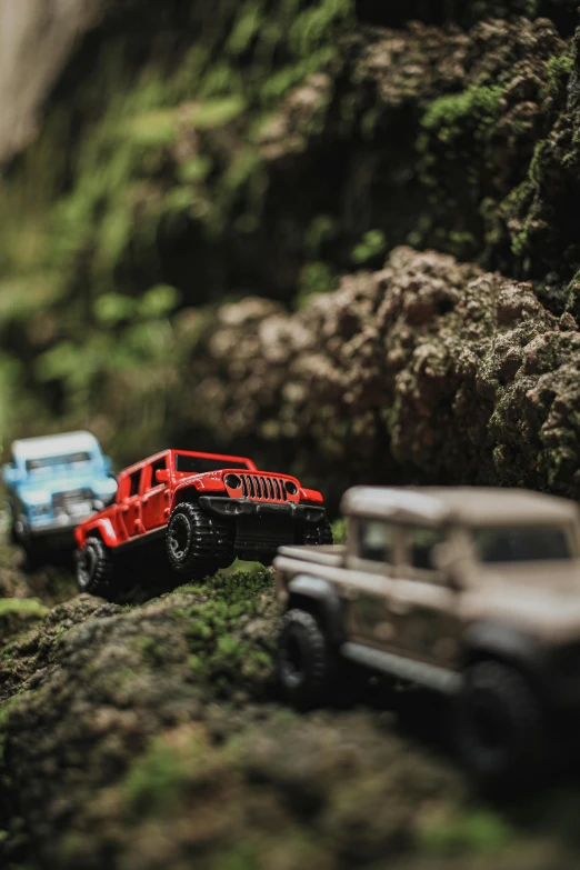 a group of toy cars sitting on top of a lush green hillside, unsplash, photorealism, jeep wrangler, cave exploration, close-up photo, instagram post