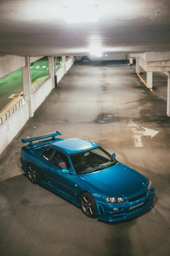 a blue car parked in a parking garage, inspired by Elsa Bleda, pexels contest winner, cobbled together nissan r34 gtr, portrait of jerma985, new zealand, high angle