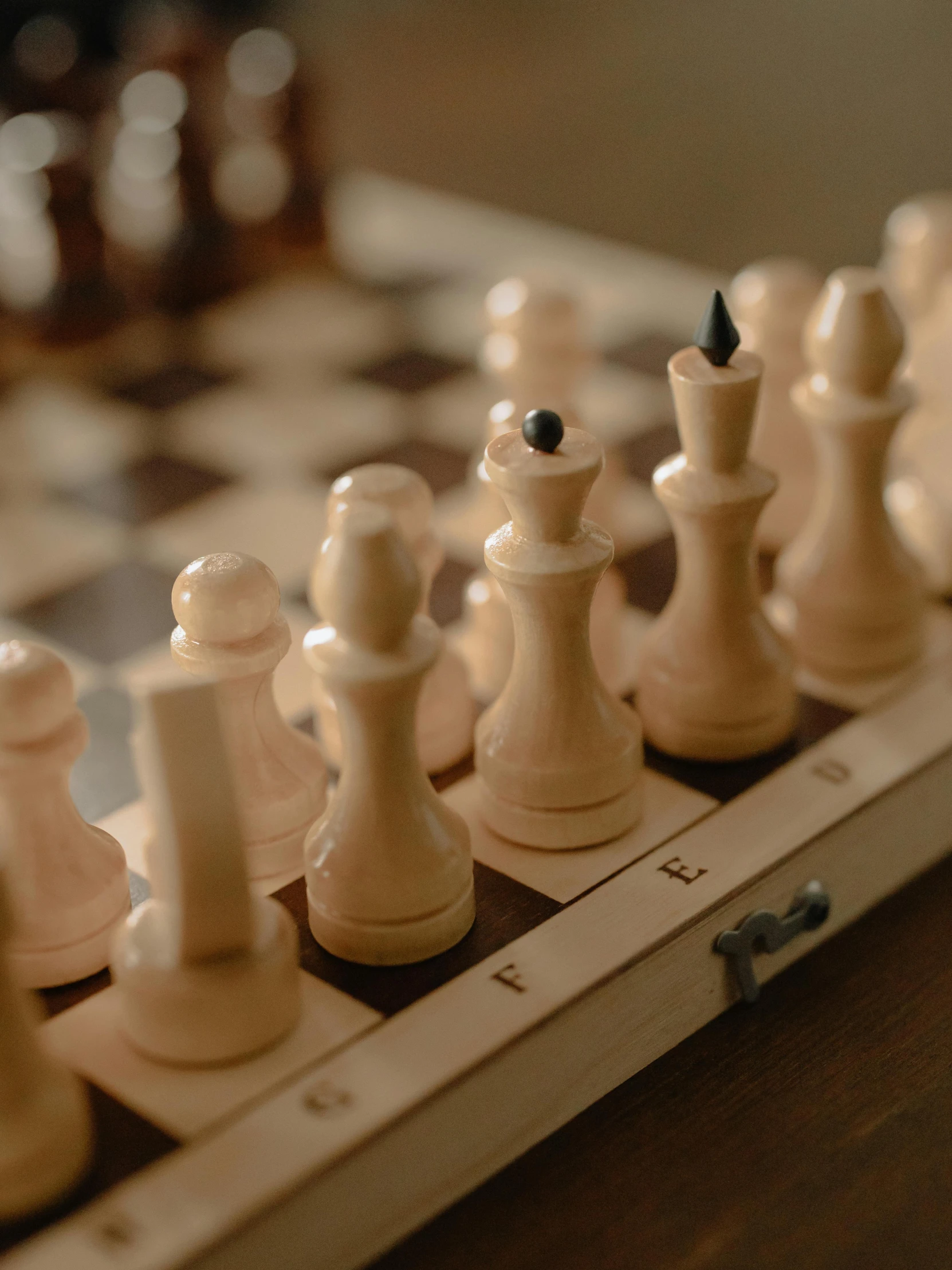 a wooden chess board with chess pieces on it, by Adam Marczyński, trending on unsplash, cream and white color scheme, game case, thumbnail, closeup of arms