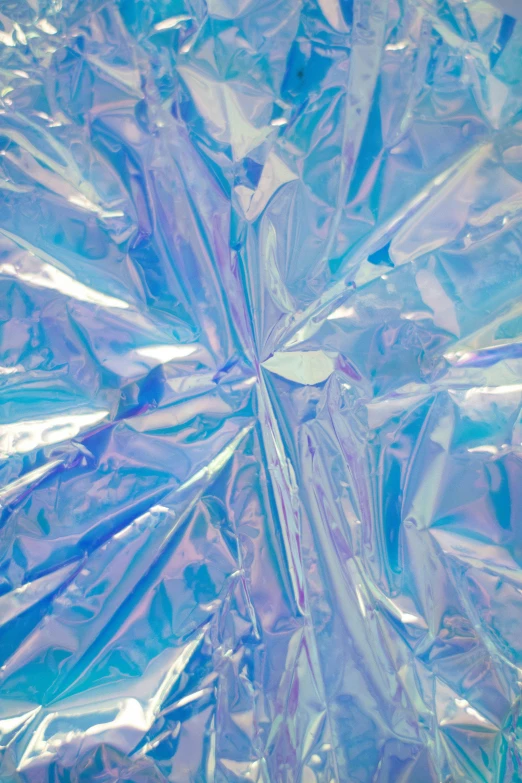 a piece of foil sitting on top of a table, by Rachel Reckitt, trending on unsplash, holography, blue-fabric, vaporwave textures, ice crystal armor, light-blue