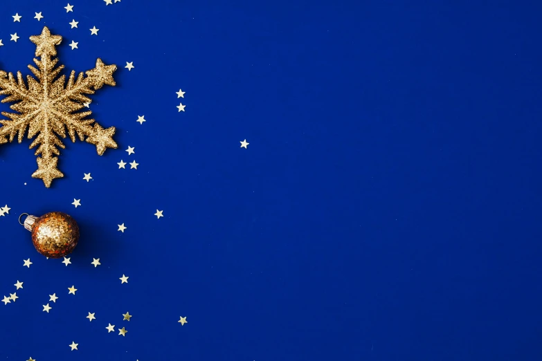 a snowflake and christmas decorations on a blue background, an album cover, inspired by Yves Klein, pexels contest winner, magical realism, european union flag, tiny stars, gold decorations, starry sky 8 k