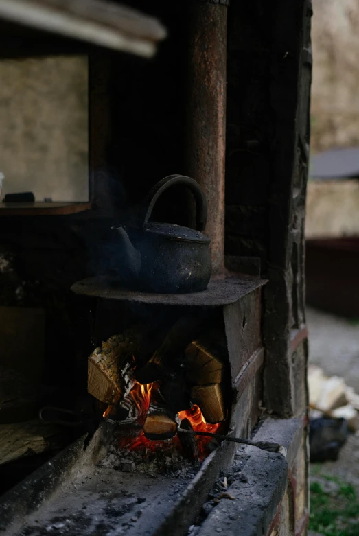 a stove with a pot on top of it, burning buildings, rustic setting, up close, fully functional