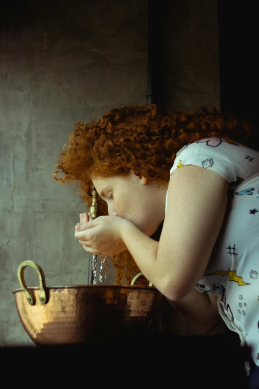 a woman drinking water out of a copper pot, inspired by Gerrit Dou, pexels, curly red hair, still from film, teenage girl, praying