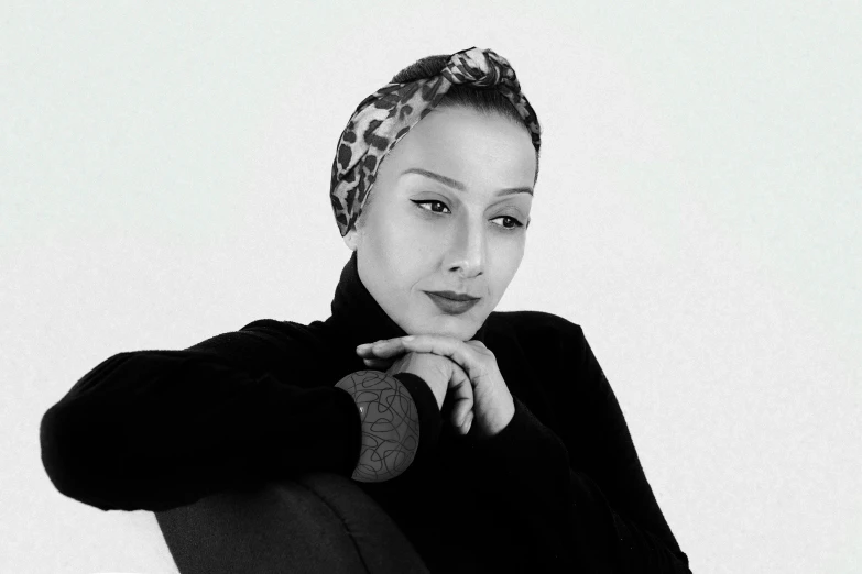 a black and white photo of a woman sitting on a chair, inspired by Méret Oppenheim, pexels contest winner, arabesque, wearing a head scarf, oyama kojima, promotional image, headshot profile picture