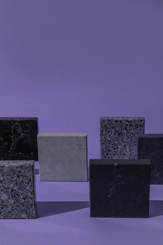 a group of granite blocks on a purple background, by Winona Nelson, all black matte product, synthetic materials, architectural finishes, sustainable materials