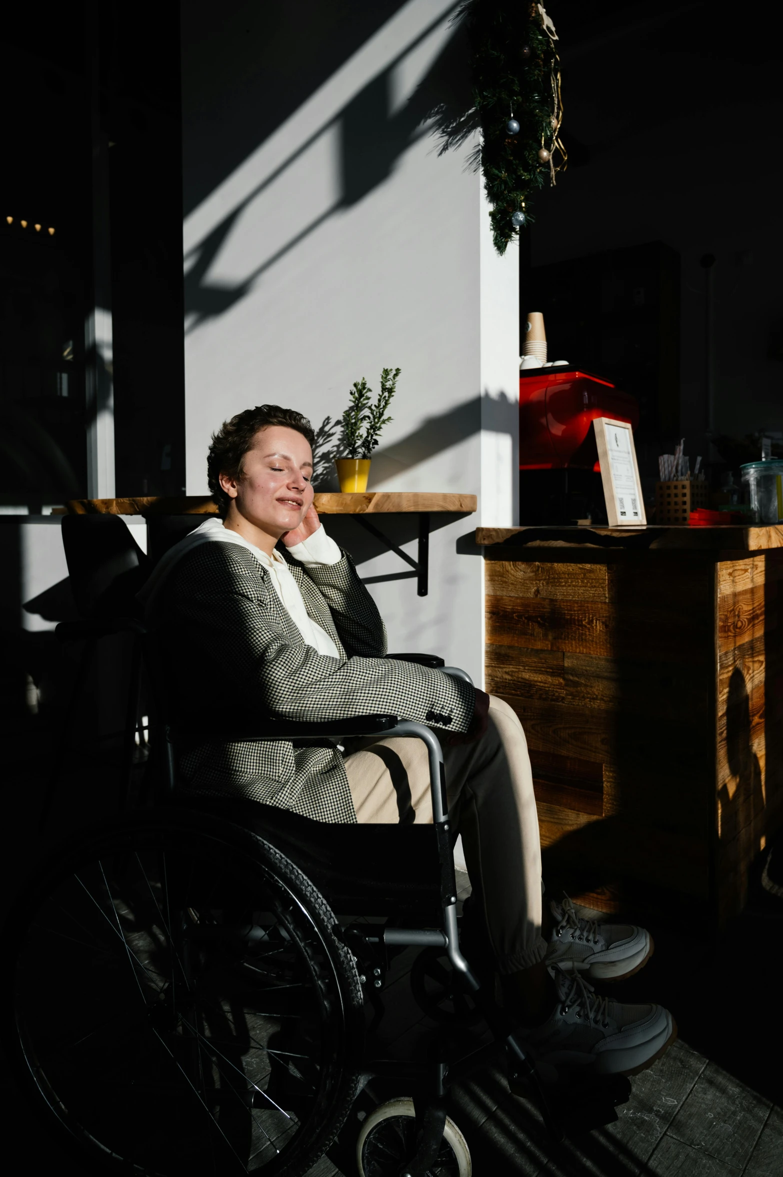 a man sitting in a wheel chair in a room, a portrait, by Jan Tengnagel, pexels, sun behind her, sitting in a cafe, surburb woman, profile image