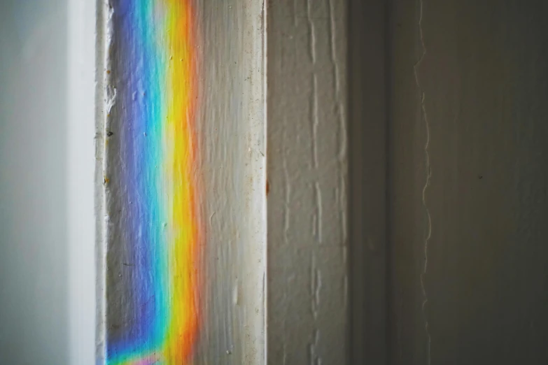 a close up of a window with a rainbow on the window sill, trending on pexels, holography, paint peeling off the walls, doorway, light refracting, on a gray background