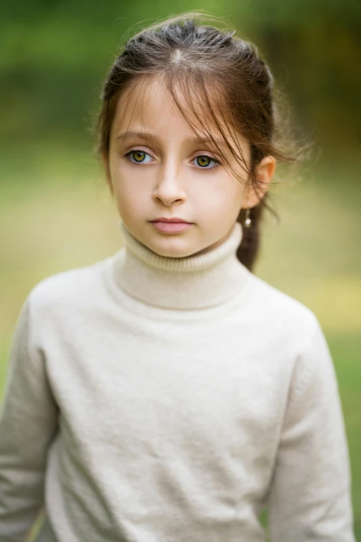 a little girl that is standing in the grass, an album cover, by Lilia Alvarado, pexels contest winner, renaissance, in white turtleneck shirt, serious look, 🤤 girl portrait, fair olive skin