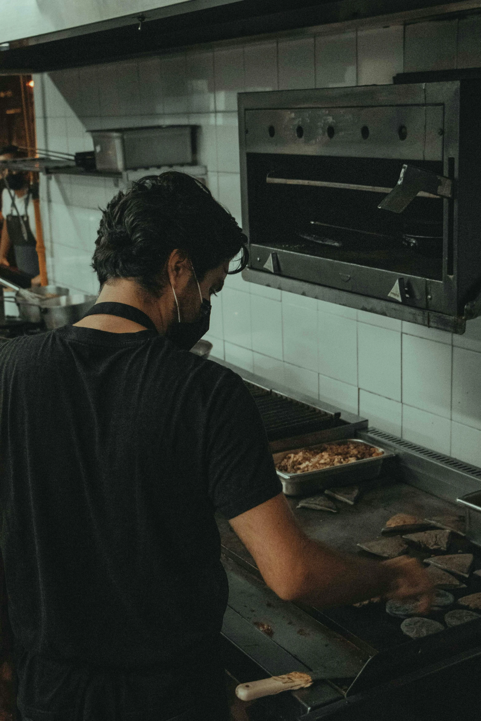 a man standing in a kitchen preparing food, profile pic, faded and dusty, caio santos, maintenance