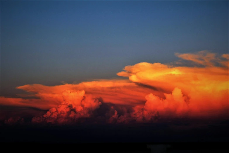 a couple of clouds that are in the sky, by Steven Belledin, pexels contest winner, orange and red lighting, humid evening, photo realistic”, amazing color photograph