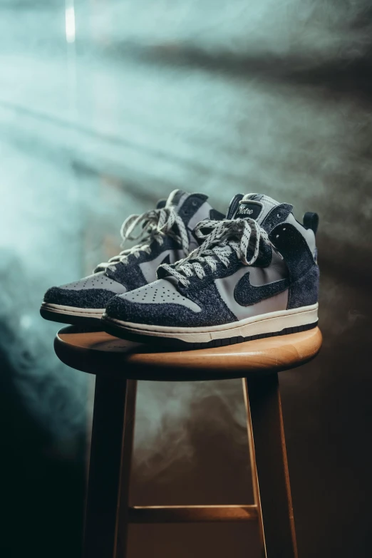 a pair of sneakers sitting on top of a stool, a portrait, unsplash contest winner, photorealism, intricate highly detailed 8 k, blue and grey, nike alpha huarache 7 elite, (night)