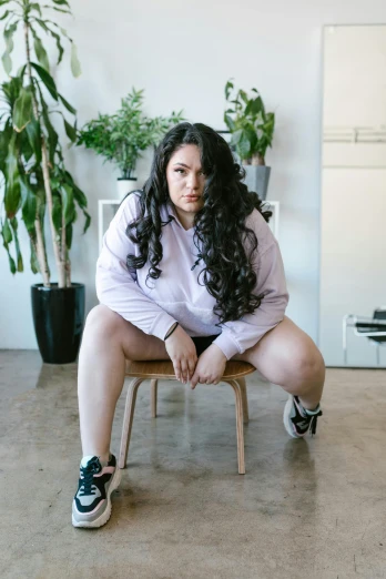 a woman sitting on top of a wooden chair, unsplash, renaissance, an overweight, woman in streetwear, thick dark hair, an all white human