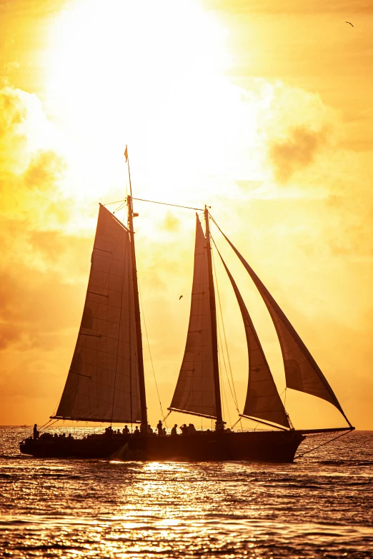 a sailboat sailing in the ocean at sunset, ships with sails underneath, golden hues, tyndall rays, beer