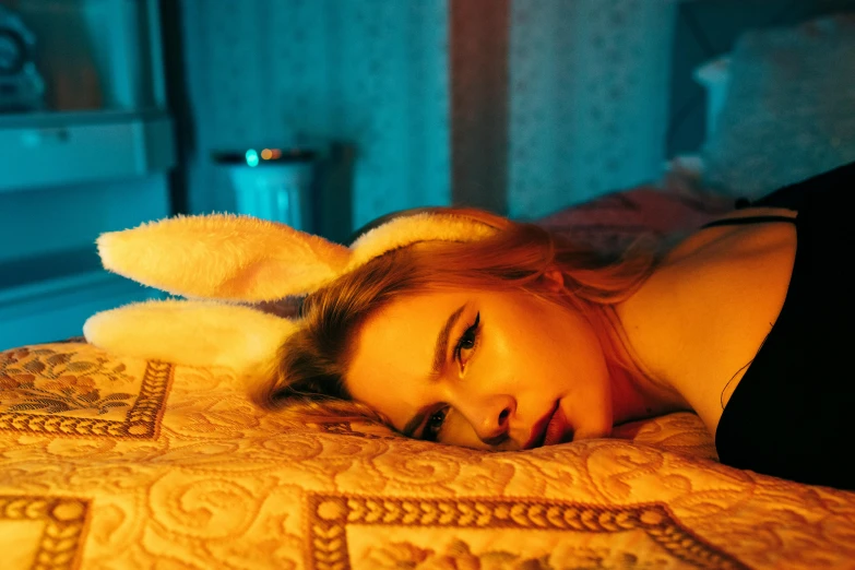 a beautiful young woman laying on top of a bed, inspired by Elsa Bleda, trending on pexels, magic realism, wearing a bunny suit, soft calm warm neon atmosphere, chloe moretz, sydney sweeney