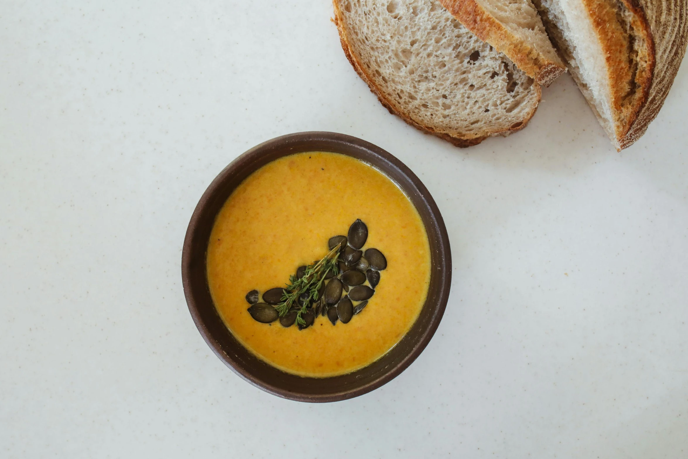 a bowl of soup next to a loaf of bread, unsplash, 🦩🪐🐞👩🏻🦳, yellow aureole, detailed product image, pumpkin