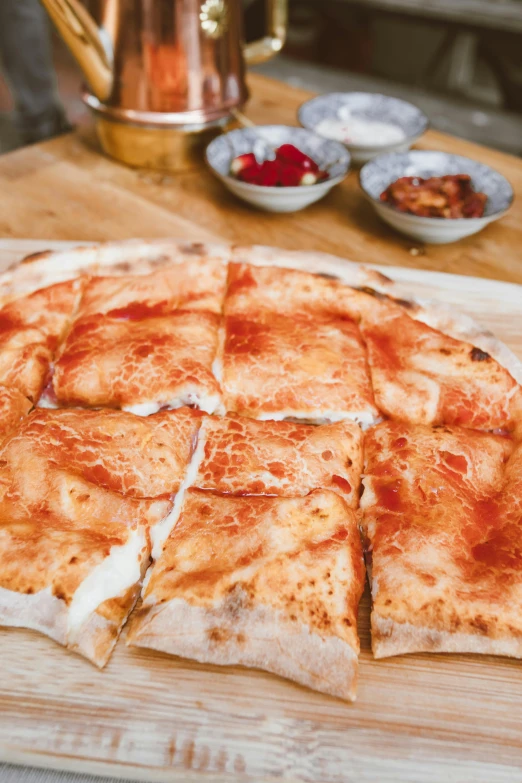 a pizza sitting on top of a wooden cutting board, by Julia Pishtar, hurufiyya, red caviar instead of sand, sichuan, square, mongol