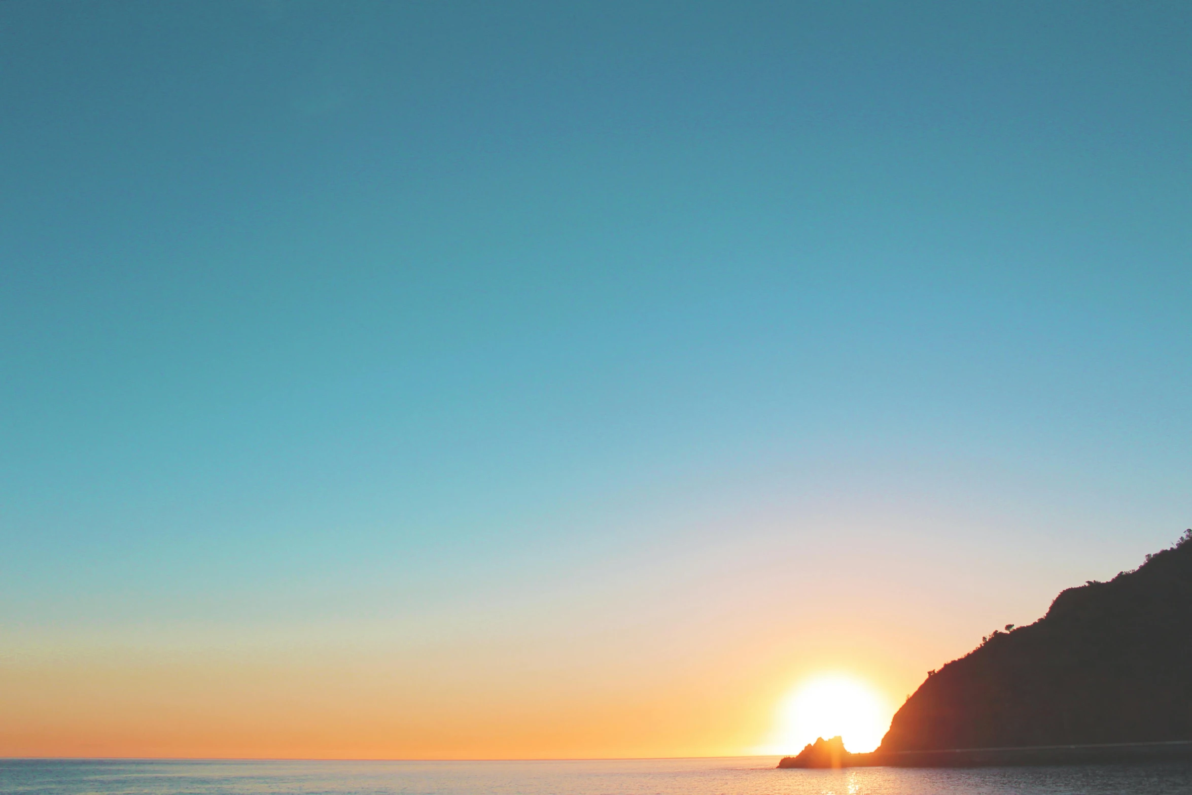 a man riding a surfboard on top of a sandy beach, unsplash, minimalism, sun rises between two mountains, pacific northwest coast, teal and orange colours, rinko kawauchi