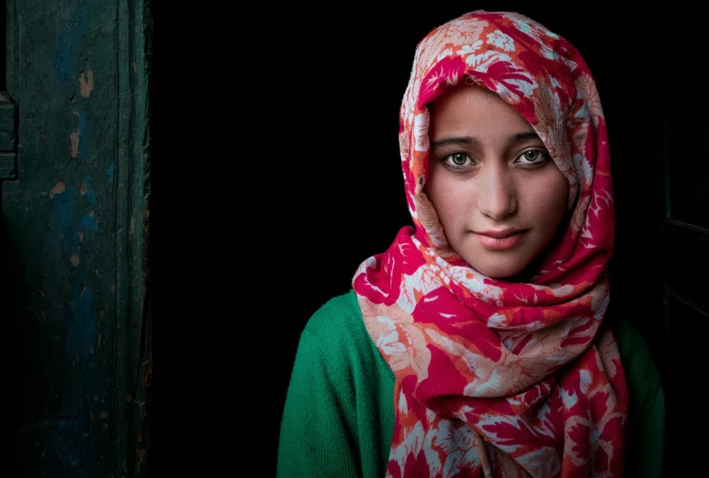 a close up of a person wearing a headscarf, a portrait, inspired by Steve McCurry, shutterstock contest winner, hurufiyya, frontal portrait of a young, green and red, nepal, square