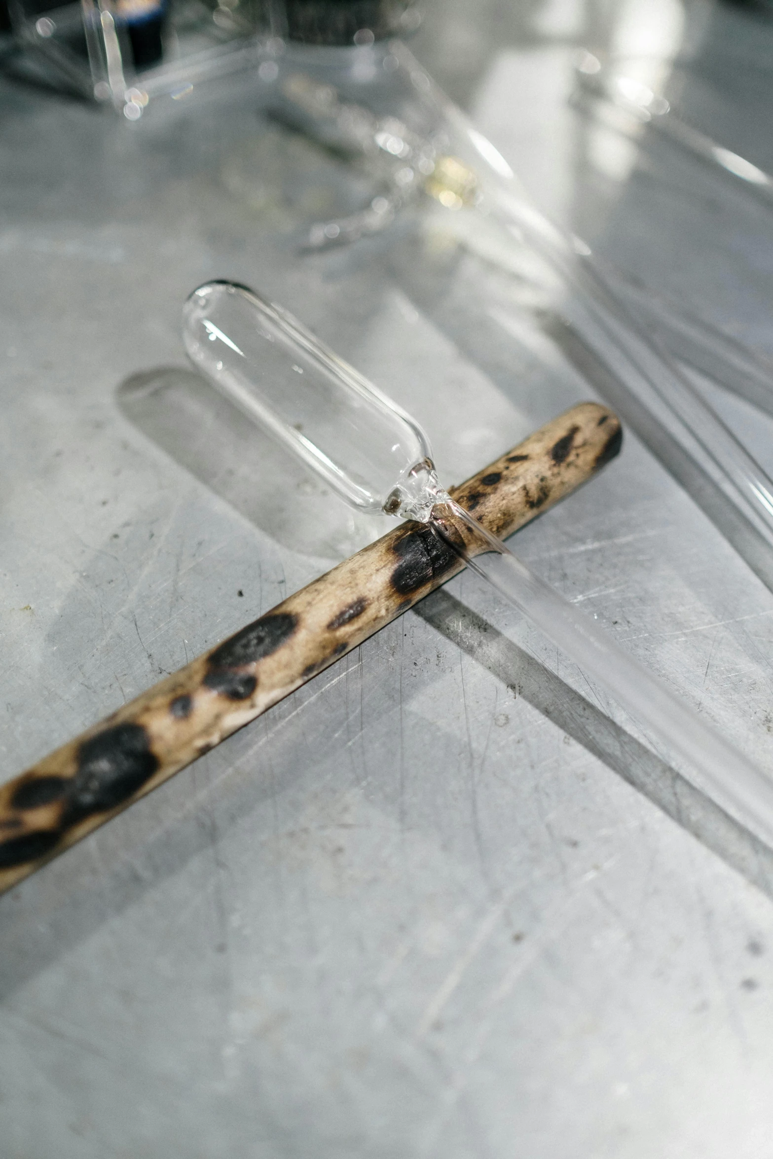 a pen sitting on top of a table covered in plastic, assemblage, fire staff, with clear glass, white with chocolate brown spots, detail shot