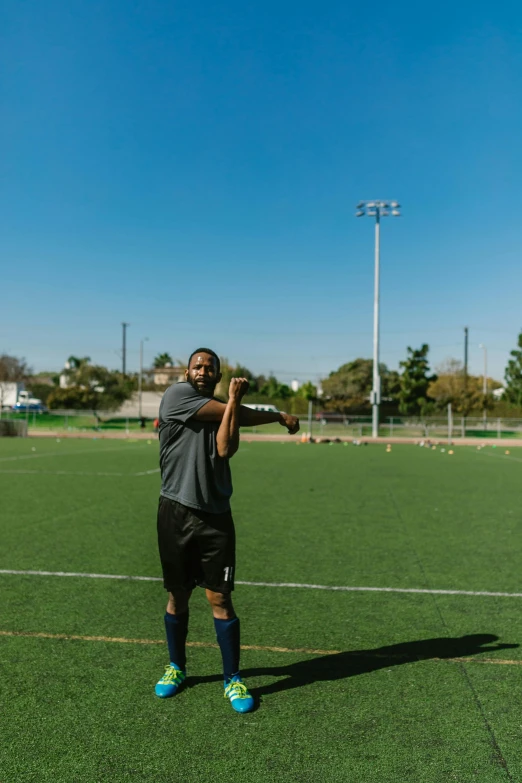 a man standing on top of a soccer field, pointing at the camera, jamal campbell, distance shot, full res