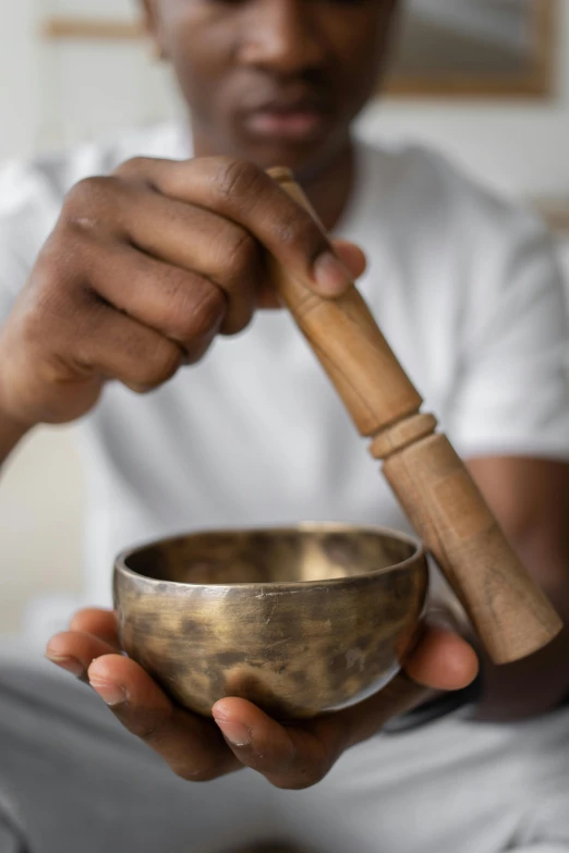 a man holding a singing bowl in his hands, trending on pexels, grey, thumbnail, made of bronze, kami