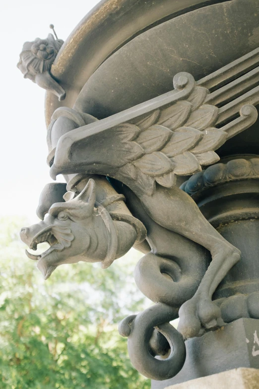 a statue of a winged horse on the side of a building, closeup of arms, sculpted draconic features, pillars, third lion head