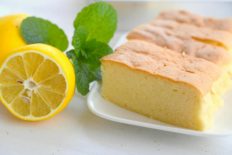 a piece of cake on a plate next to a lemon, by Tsuruko Yamazaki, unsplash, hurufiyya, mint, rectangle, blender, bread