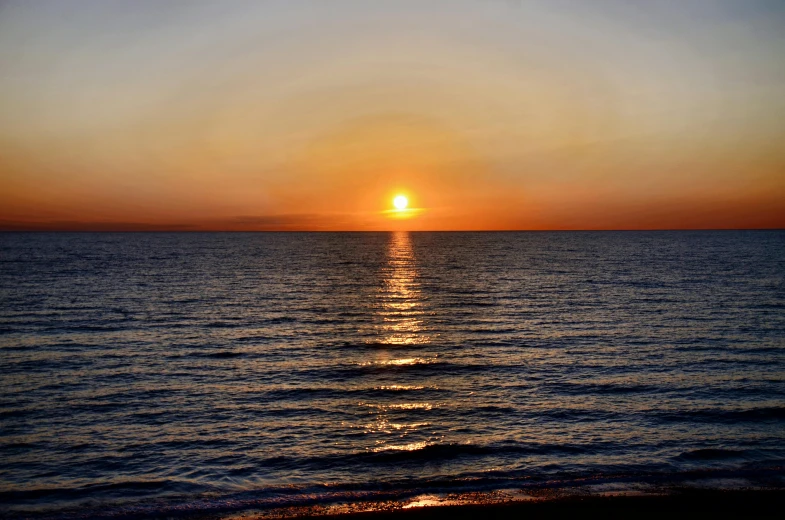 the sun is setting over a body of water, by Robbie Trevino, pexels contest winner, black sea, halogen, widescreen, no cropping