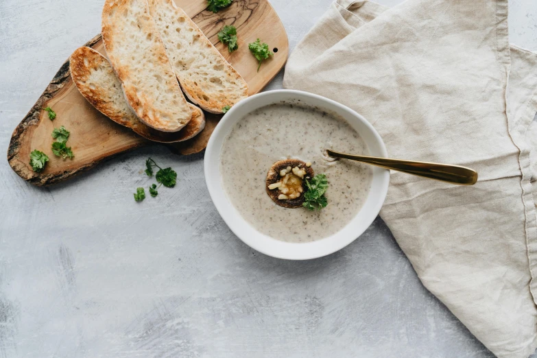 a bowl of soup and some bread on a table, by Nicolette Macnamara, pexels contest winner, renaissance, taupe, mushroom, white background, background image