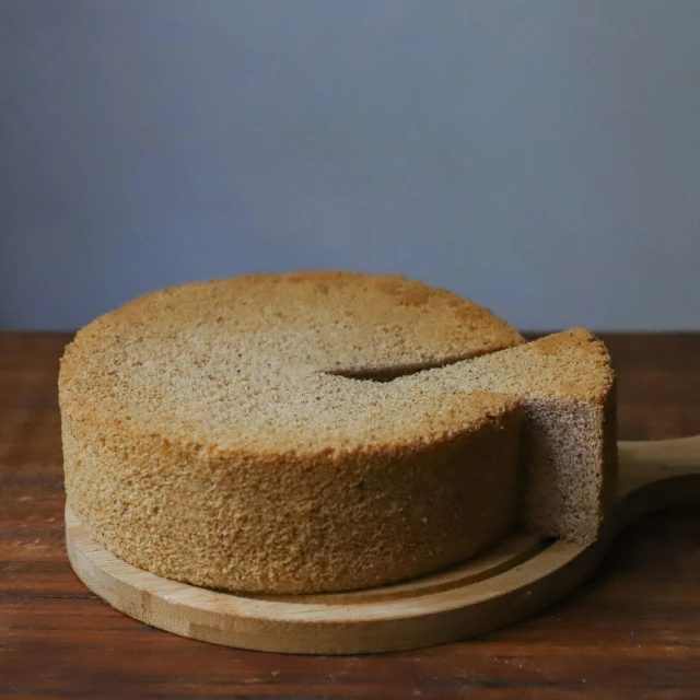 a cake sitting on top of a wooden cutting board, by Yasushi Sugiyama, hurufiyya, menger sponge, taupe, medium-shot, round format