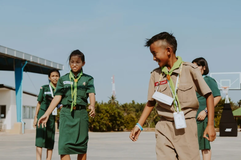 a group of young boys standing next to each other, pexels contest winner, happening, girl wearing uniform, wearing green, on a landing pad, patiphan sottiwilai