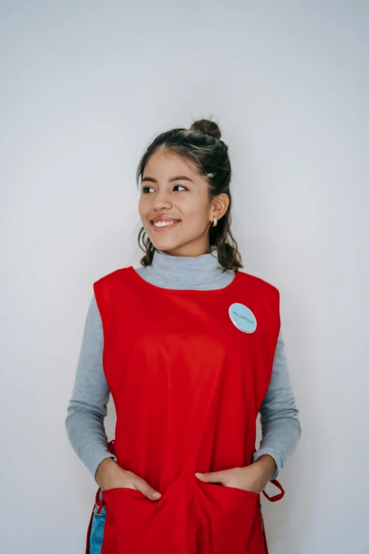a woman standing with her hands in her pockets, by Olivia Peguero, pexels contest winner, hurufiyya, wearing a red turtleneck sweater, technical vest, teen girl, official product photo