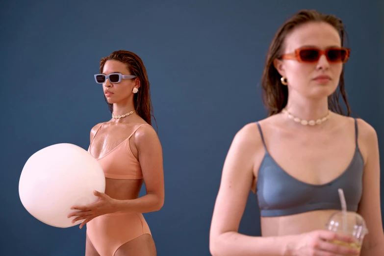 a woman in a bikini holding a beach ball, trending on unsplash, bauhaus, two models in the frame, muted colors. ue 5, with mirrorshades sunglasses, wearing a cropped tops