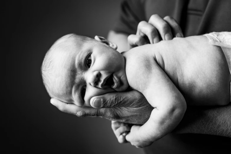 a man holding a baby in his arms, a black and white photo, by Caroline Mytinger, pexels, medical photography, holding an epée, portrait!!!!, thumbnail