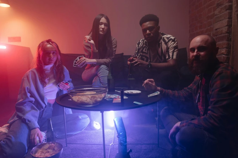 a group of people sitting around a table, inspired by Liam Wong, ramatic cinematic lighting, led gaming, smoking a magical bong, mkbhd