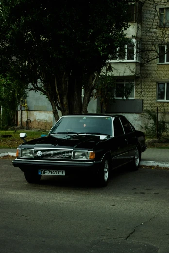 a black car parked on the side of the road, an album cover, by Attila Meszlenyi, pexels contest winner, 1985 cheverlot k20 c10, kama russian electrocar, very handsome, hsv