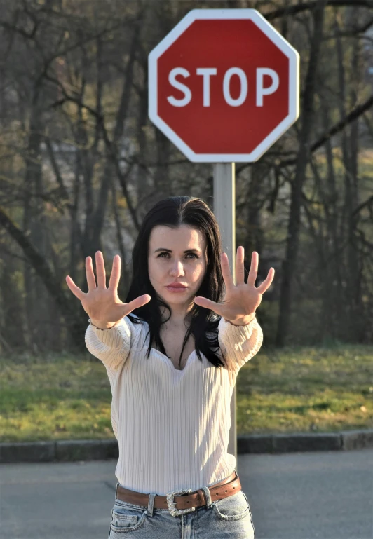 a woman standing in front of a stop sign, by Adam Marczyński, casting a protection spell, promo image, hands, official screenshot