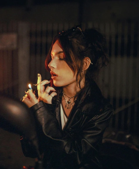a woman in a leather jacket smoking a cigarette, an album cover, inspired by Elsa Bleda, trending on pexels, madison beer, alessio albi, high quality photo, sydney hanson