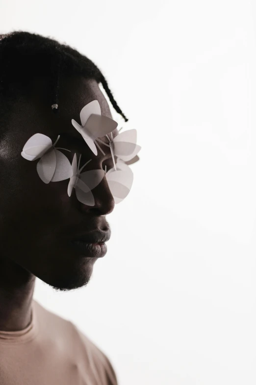 a man with a flower on his face, an album cover, by Lily Delissa Joseph, unsplash, afrofuturism, shades, kara walker, loosely cropped, light from right