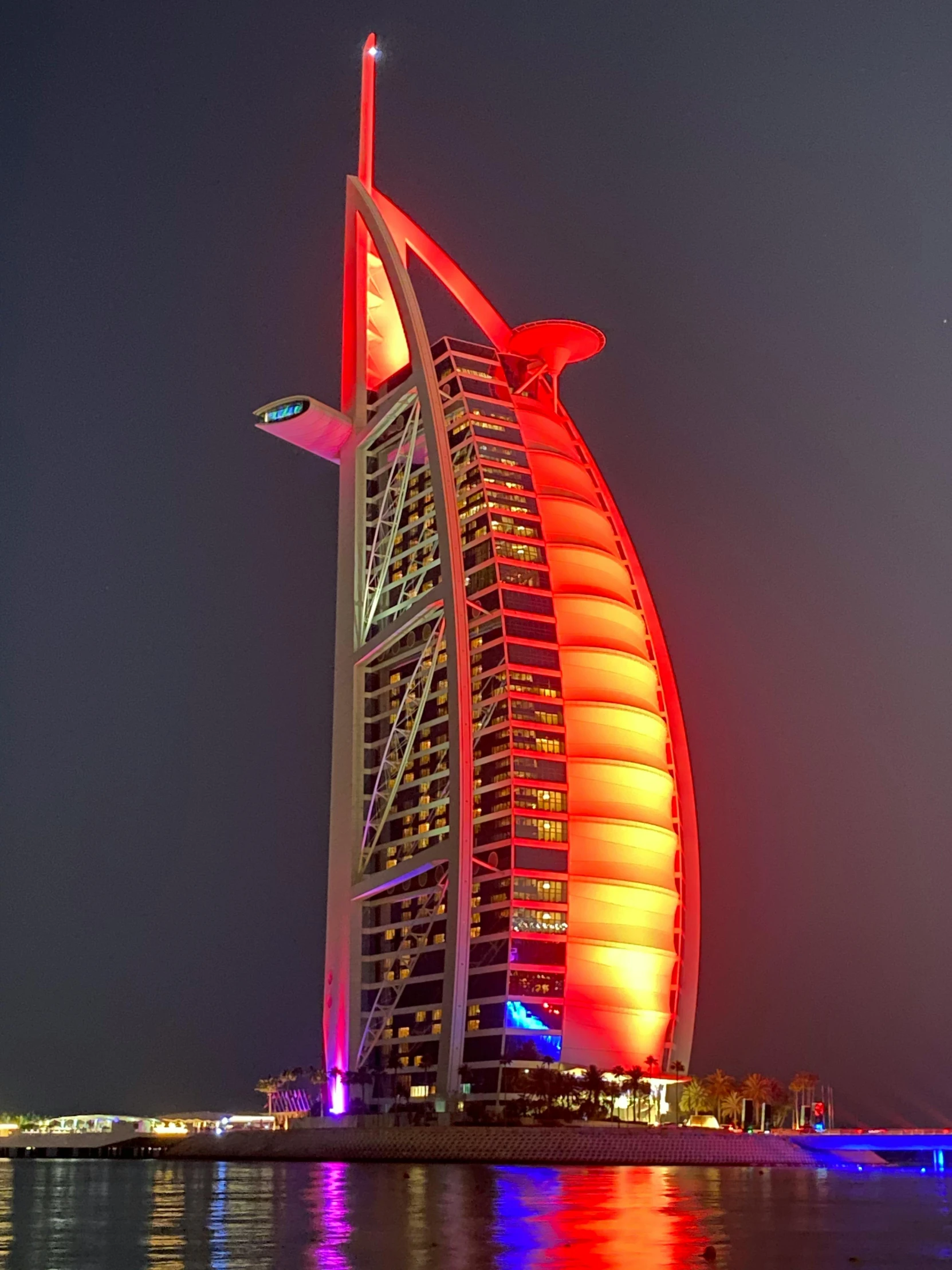 the burj al arab hotel lit up at night, an album cover, pexels contest winner, reddish exterior lighting, profile image, bad photo, dsrl photo