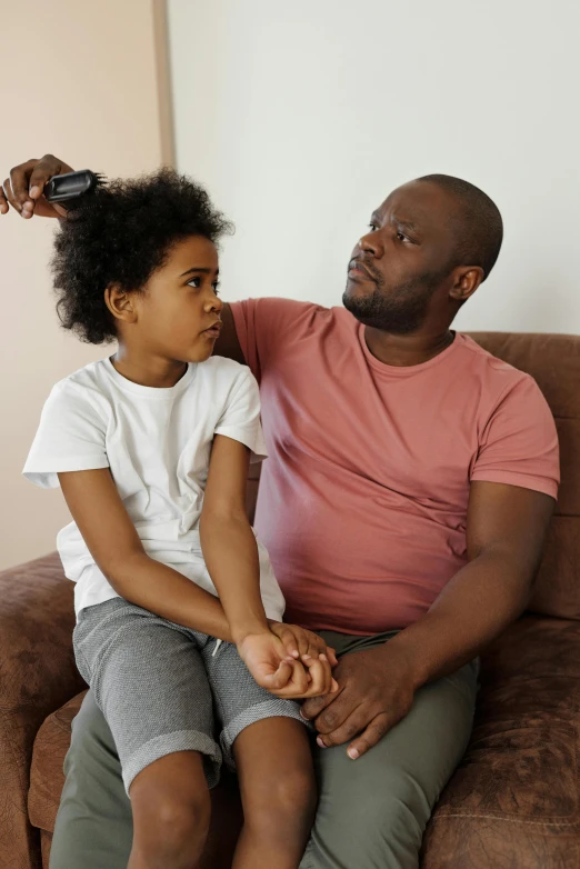 a man and a little girl sitting on a couch, pexels contest winner, renaissance, afro comb, thinning hair, hairdryer, reassuring