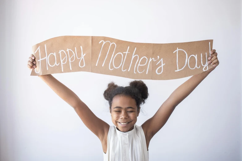 a woman holding a sign that says happy mother's day, by Will Ellis, pexels contest winner, arms spread wide, avatar image, ribbon, an olive skinned