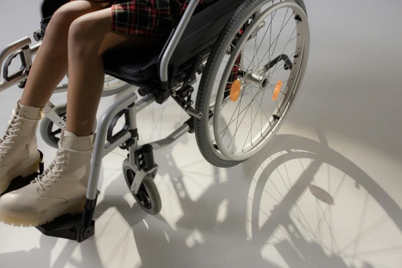 a close up of a person in a wheel chair, an album cover, pexels, hurufiyya, teenage girl, detailed with shadows, medical equipment, leg high