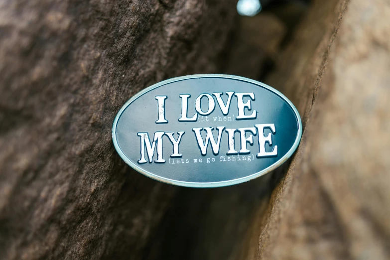 a metal sign that says i love my wife, by Joe Bowler, unsplash, silver insignia, 👰 🏇 ❌ 🍃, magnificent oval face, tombstone