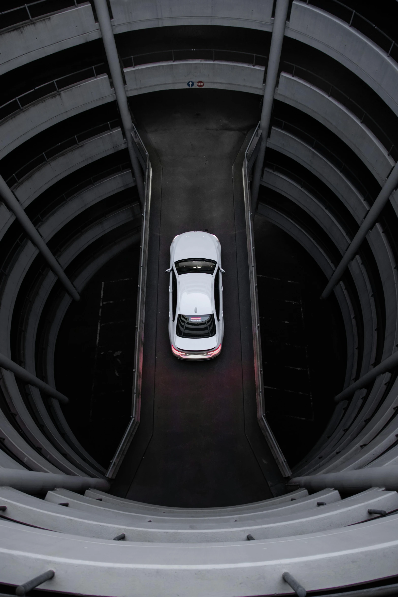 a white car is driving through a tunnel, circle pit, looking down from above, spaceship hangar, promo image