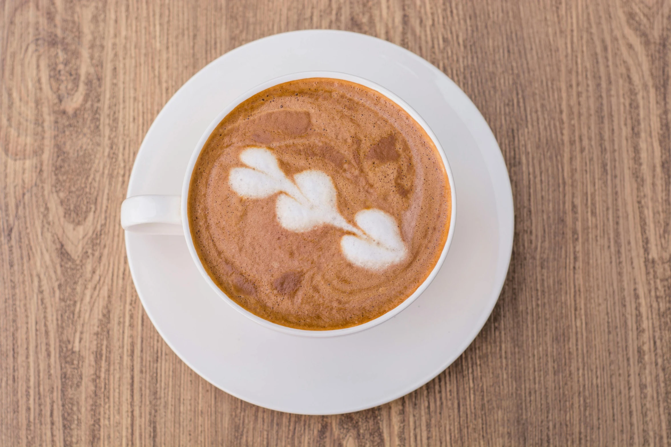 a cup of coffee sitting on top of a wooden table, profile image