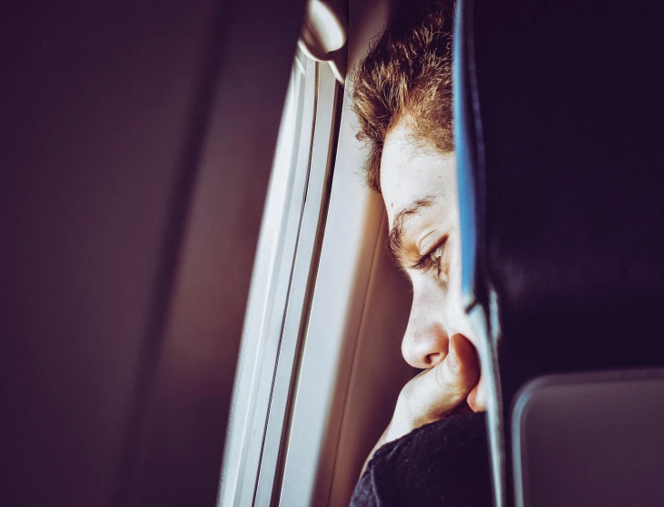 a close up of a person looking out a window, aeroplane, sleepy expression, head down, instagram post