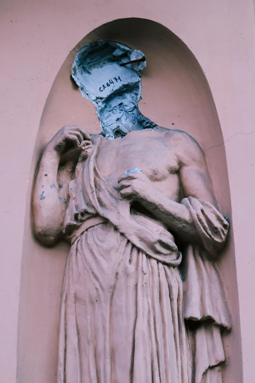 a statue that is on the side of a building, a statue, inspired by Cagnaccio di San Pietro, street art, ripped flesh, greek elements, clay model, 1997 )