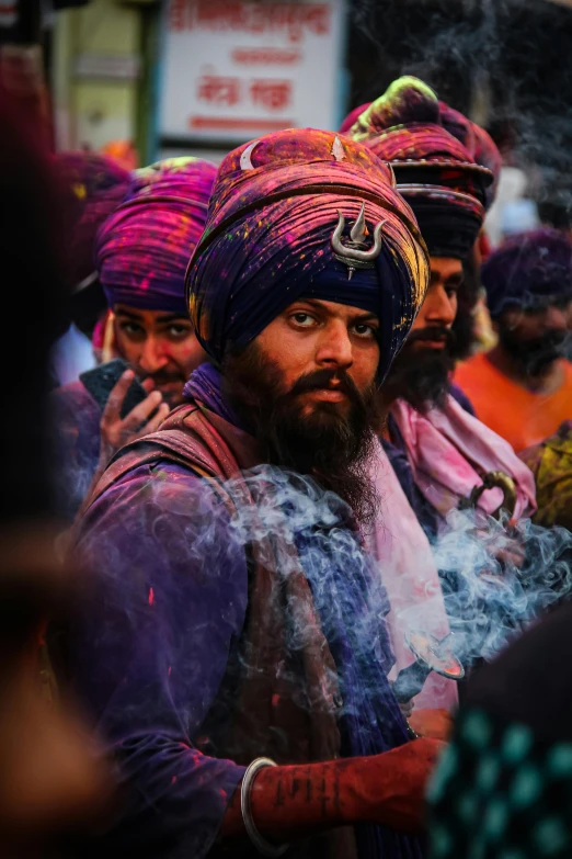 a group of men standing next to each other, an album cover, inspired by Steve McCurry, pexels contest winner, turban, rainbow smoke, festival of rich colors, staring hungrily