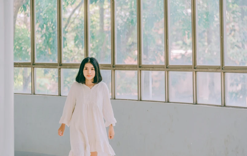 a woman in a white dress standing in front of a window, inspired by Kim Tschang Yeul, pexels contest winner, long shirt, kotegawa yui, a woman walking, ethnicity : japanese